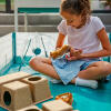 Une fille jouant avec son hamster dans un parc avec divers accessoires