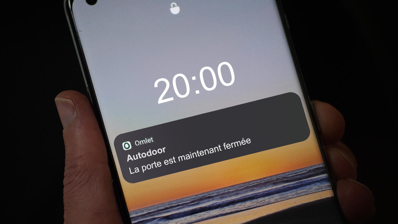 écran de téléphone avec notification de l'application smart Autodoor en soirée