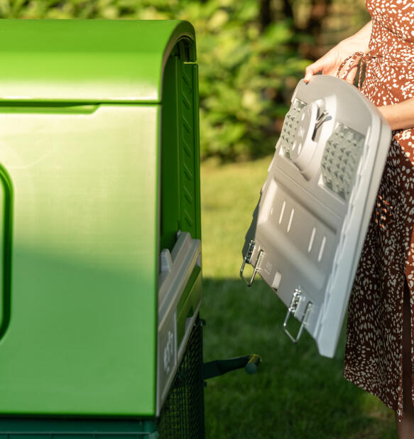 femme qui retire la partie arrière d’un poulailler eglu cube