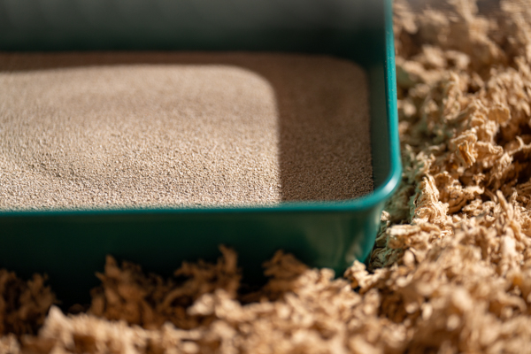 Gros plan sur une baignoire de sable pour hamster de couleur bleu sarcelle à l’intérieur de la cage spacieuse Hamster Home d’Omlet.